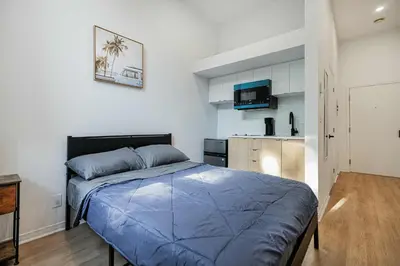 a bedroom with a blue bed and a kitchen at Great apartment with parking in Montréal