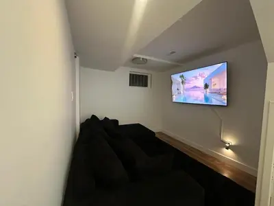 a living room with a couch and a flat screen tv at luxury townhouse in Montreal in Longueuil