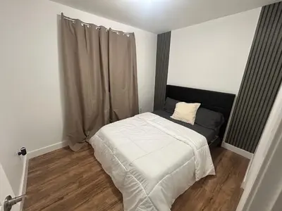 a small bedroom with a bed and a window at luxury townhouse in Montreal in Longueuil