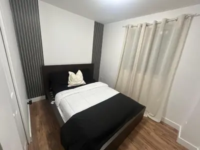 a small bedroom with a black and white bed with curtains at luxury townhouse in Montreal in Longueuil