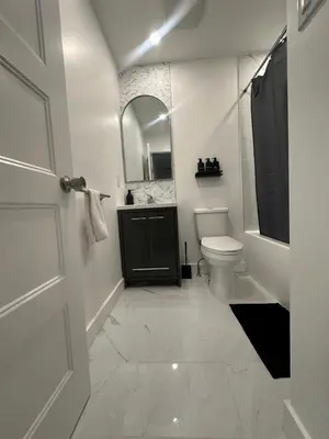 a white bathroom with a toilet and a mirror at luxury townhouse in Montreal in Longueuil