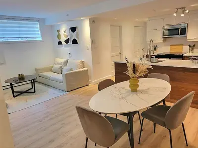 a kitchen and a living room with a table and chairs at Urban Serenity NDG in Montréal
