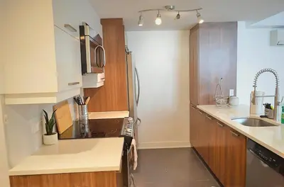 a kitchen with a sink and a refrigerator at Urban Serenity NDG in Montréal