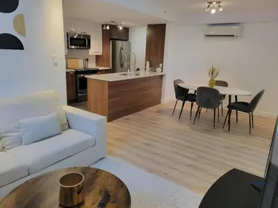 a living room with a white couch and a table at Urban Serenity NDG in Montréal