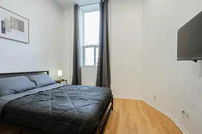 a bedroom with a bed and a large window at Fabulous Studio with FREE Parking near Montreal Downtown in Montréal