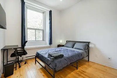 a bedroom with a bed and a desk and a window at Fabulous Studio with FREE Parking near Montreal Downtown in Montréal