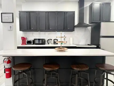 a kitchen with black cabinets and bar stools at Downtown Private Room & Workspace Metros Sherbrooke & Berri! Fast Wifi! in Montréal