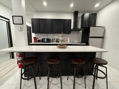 a kitchen with a white counter and bar stools at Downtown Private Room & Workspace Metros Sherbrooke & Berri! Fast Wifi! in Montréal