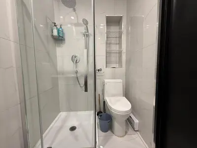 a white bathroom with a shower and a toilet at Downtown Private Room & Workspace Metros Sherbrooke & Berri! Fast Wifi! in Montréal
