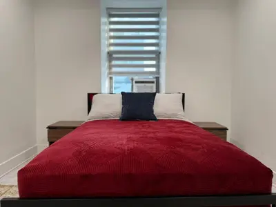 a red bed in a white room with a window at Downtown Private Room & Workspace Metros Sherbrooke & Berri! Fast Wifi! in Montréal