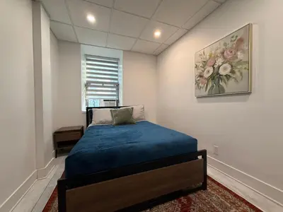 a bedroom with a bed and a painting on the wall at Downtown Private Room & Workspace Metros Sherbrooke & Berri! Fast Wifi! in Montréal
