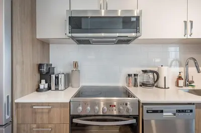 a kitchen with a stove and a microwave at Skyline Suite - Modern 1 BR in Montréal