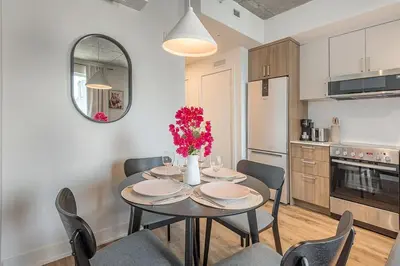 a kitchen and dining room with a table and chairs at Skyline Suite - Modern 1 BR in Montréal