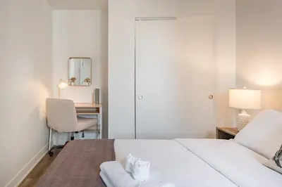 a bedroom with a bed and a desk and a chair at Skyline Suite - Modern 1 BR in Montréal