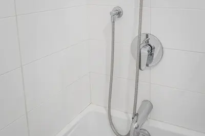 a shower in a white tiled bathroom at Skyline Suite - Modern 1 BR in Montréal