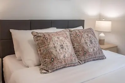 a bed with two pillows on top of it at Cozy Corner - Modern 1BR in MTL in Montréal