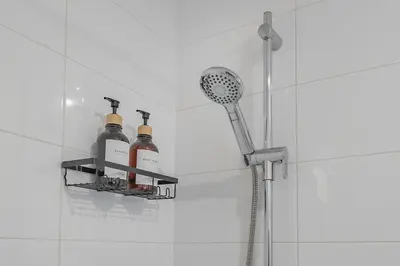 a shower with three bottles of wine on a shelf at Cozy Corner - Modern 1BR in MTL in Montréal