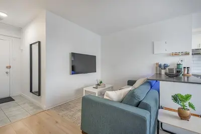 a living room with a blue couch and a tv at The Nest - Comfy 1 bedroom in Prime Location in Montréal