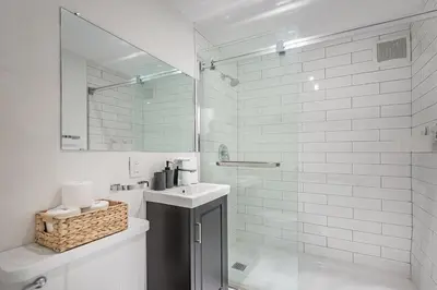 a white bathroom with a sink and a shower at The Nest - Comfy 1 bedroom in Prime Location in Montréal