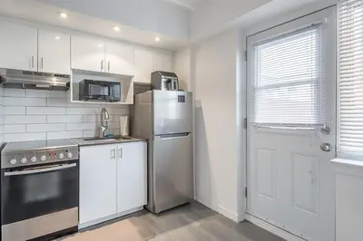 a kitchen with a stainless steel refrigerator and a door at The Nest - Comfy 1 bedroom in Prime Location in Montréal