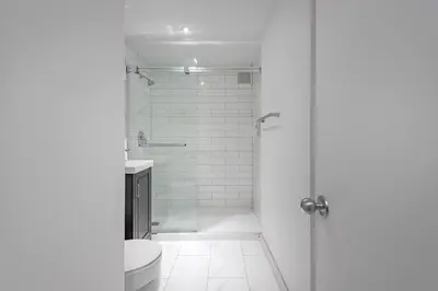 a white bathroom with a shower and a toilet at The Nest - Comfy 1 bedroom in Prime Location in Montréal