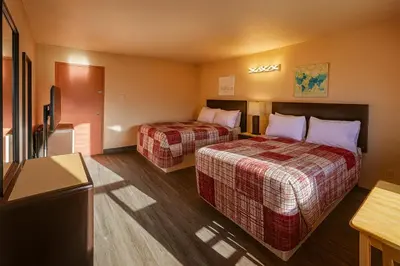 a hotel room with two beds and a flat screen tv at Motel St-Eustache in Saint-Eustache