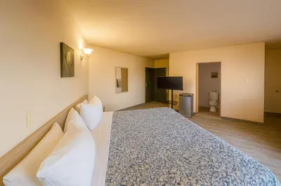 a bedroom with a large bed with white pillows at Motel St-Eustache in Saint-Eustache