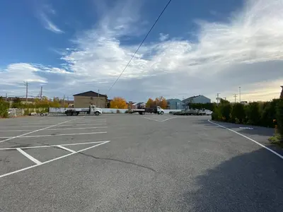 an empty parking lot with cars parked in it at Motel St-Eustache in Saint-Eustache