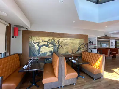 a restaurant with two tables and a painting on the wall at Motel St-Eustache in Saint-Eustache