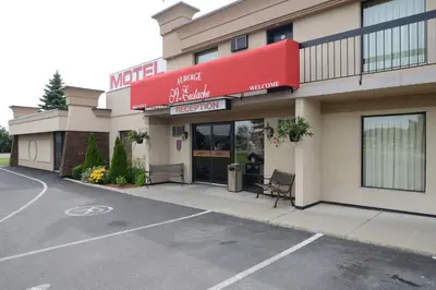 a store front of a motel with a parking lot at Motel St-Eustache in Saint-Eustache