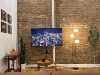 a living room with a tv on a brick wall at Top Location - The 777 Old Port Gem in Montréal