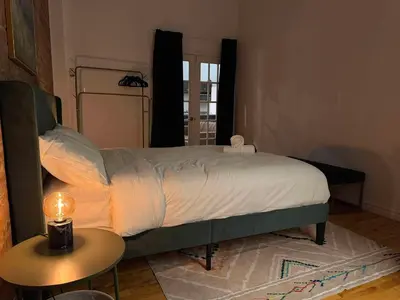 a bed in a bedroom with a table and a lamp at Top Location - The 777 Old Port Gem in Montréal