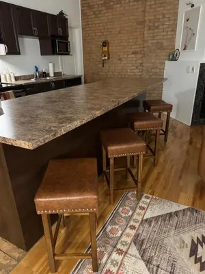 a kitchen with a large counter and stools at Top Location - The 777 Old Port Gem in Montréal