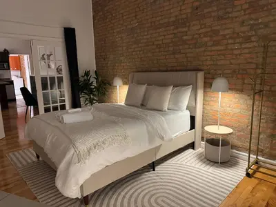 a bedroom with a large bed and a brick wall at Top Location - The 777 Old Port Gem in Montréal