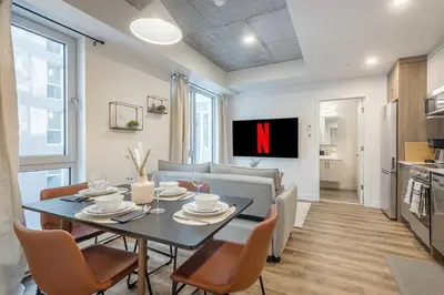 a living room with a table with chairs and a tv at Cute Gem in Downtown Montreal in Montréal