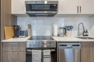 a kitchen with a stainless steel stove and a microwave at Cute Gem in Downtown Montreal in Montréal
