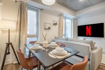 a living room with a table and a couch and a tv at Cute Gem in Downtown Montreal in Montréal