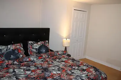 a bedroom with a bed and a lamp and a door at Perfect location brand new basement 1 bedroom full basement with kitchen in unit laundry separated in Laval