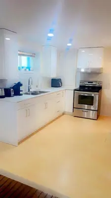 a kitchen with white cabinets and a stove top oven at Perfect location brand new basement 1 bedroom full basement with kitchen in unit laundry separated in Laval