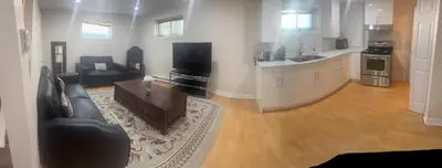 a living room with a couch and a table and a kitchen at Perfect location brand new basement 1 bedroom full basement with kitchen in unit laundry separated in Laval