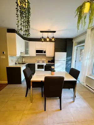 a kitchen and dining room with a table and chairs at La Pause Montréal in Montréal