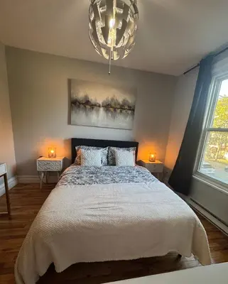 a bedroom with a large bed and a chandelier at La Pause Montréal in Montréal