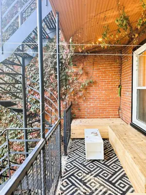 a balcony with a table and a brick wall at La Pause Montréal in Montréal