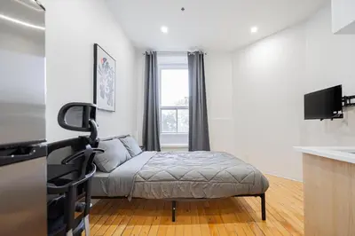 a living room with a ottoman in front of a window at Magnificent Studio with FREE parking near downtown in Montréal