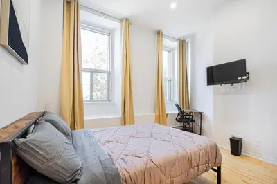 a bedroom with a bed and a flat screen tv at Magnificent Studio with FREE parking near downtown in Montréal
