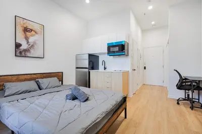 a bedroom with a bed and a desk in a room at Magnificent Studio with FREE parking near downtown in Montréal