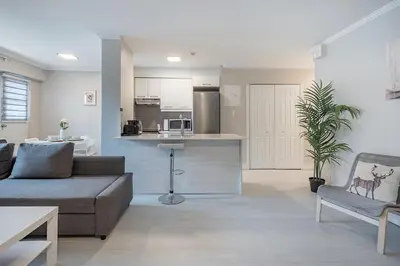 a living room with a couch and a kitchen at Cozy 1BR - Heart of Montreal in Montréal