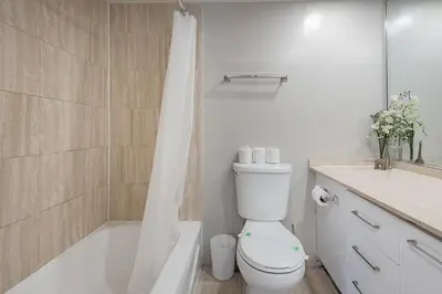a bathroom with a toilet and a tub and a shower at Cozy 1BR - Heart of Montreal in Montréal