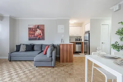 a living room with a couch and a kitchen at Outstanding 1BR in Heart of Downtown Montreal in Montréal