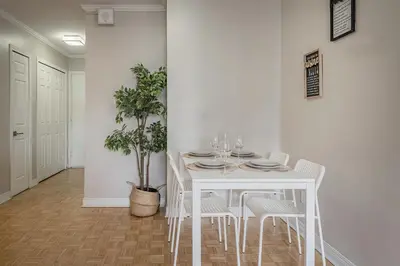 a white dining room with a white table and chairs at Outstanding 1BR in Heart of Downtown Montreal in Montréal
